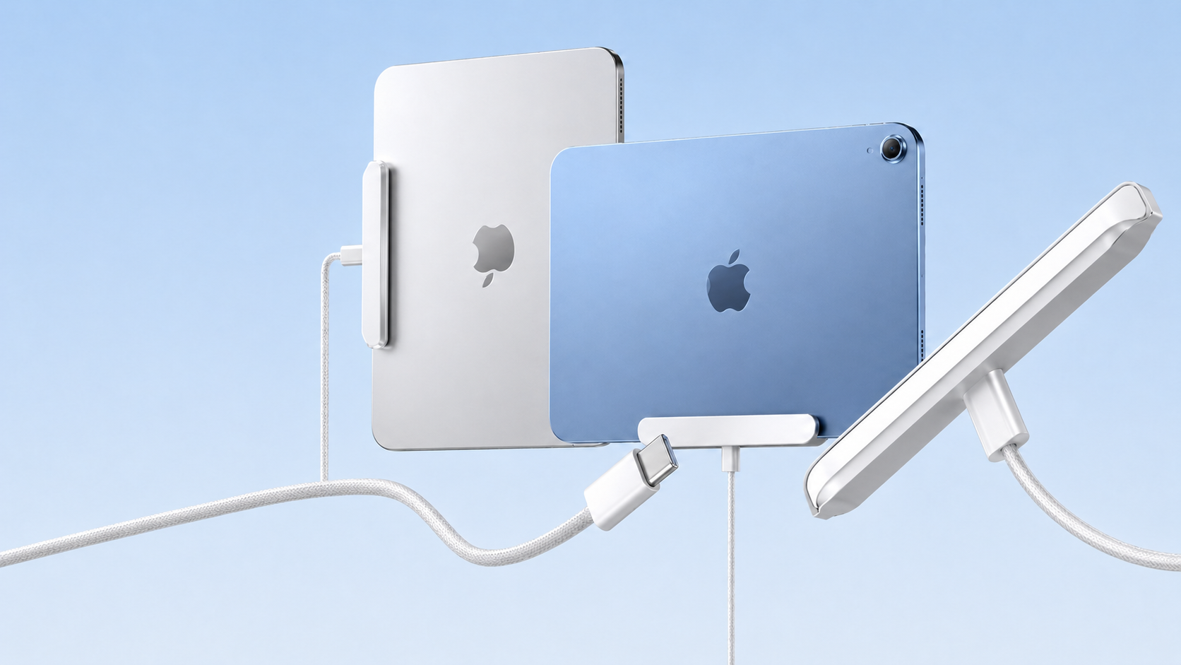シルバーとブルーのiPadが充電ケーブルに接続されています。