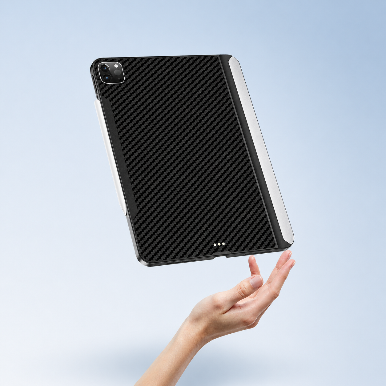 黒カーボンファイバーのiPadケース、女性の手で宙に浮くデザイン。